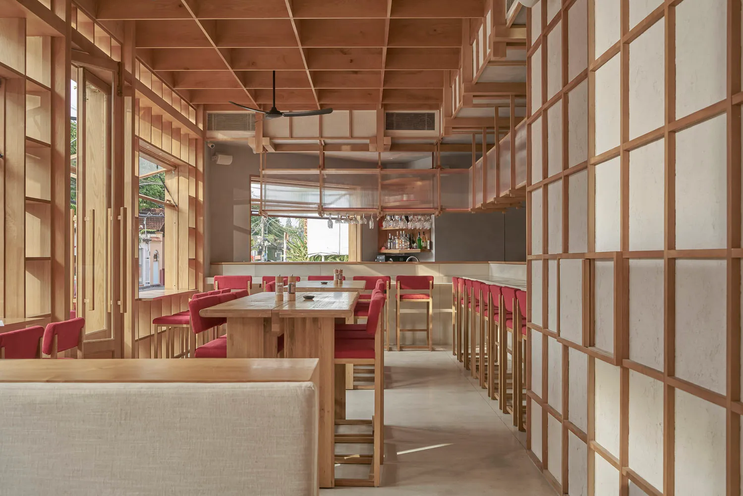A modern restaurant interior with wooden tables and white walls.