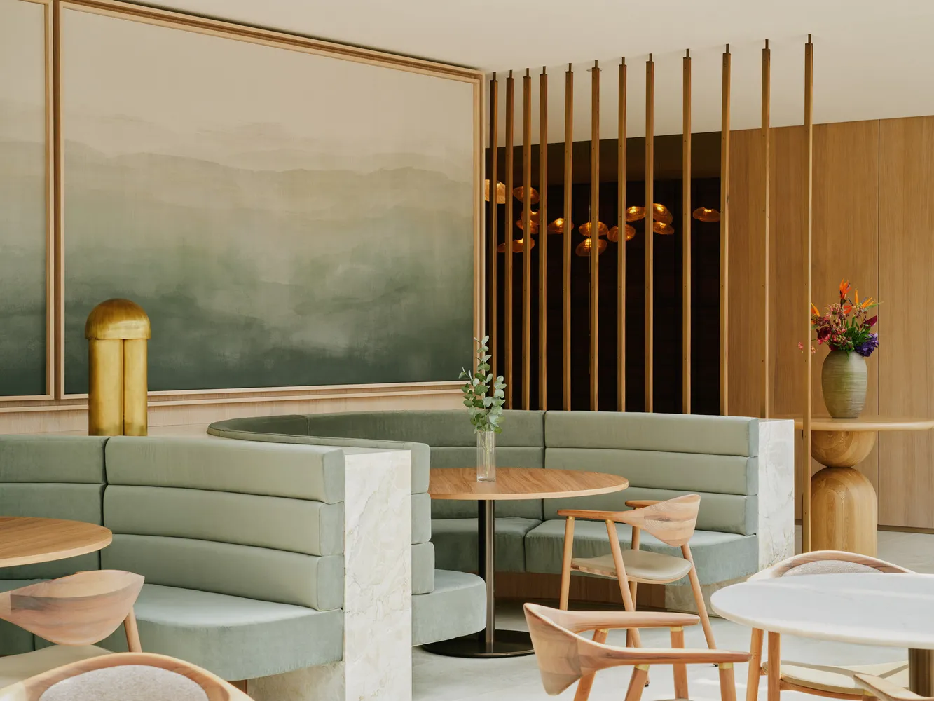 A modern restaurant interior with booth seating upholstered in suede and accented with marble and wood.