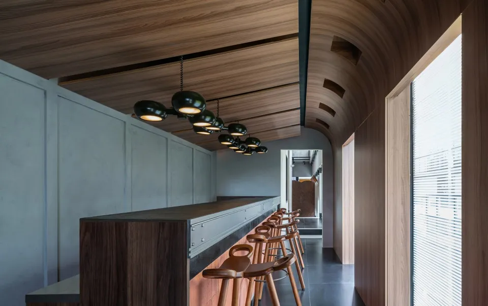 A modern interior design featuring a bar counter made of wood and concrete.