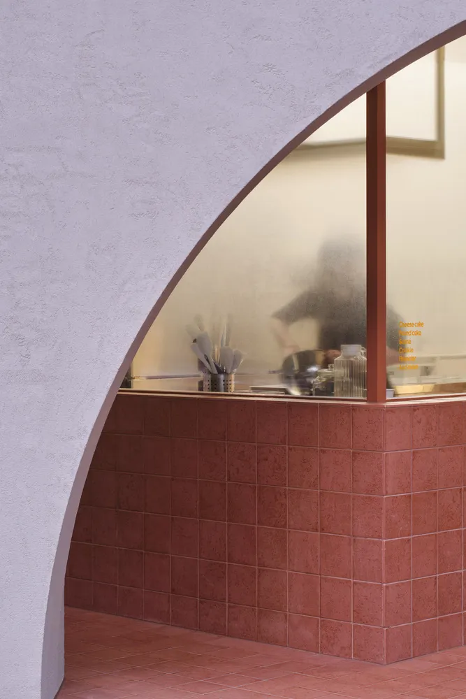 A modern cafe with a tiled counter and gradient archway