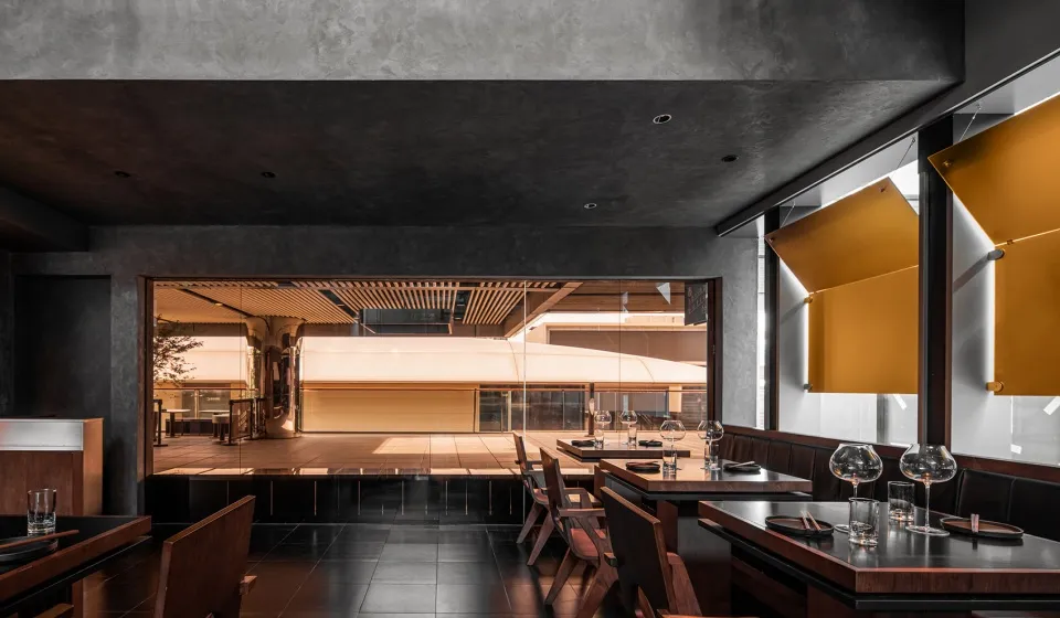 Modern restaurant interior with concrete walls and wooden tables