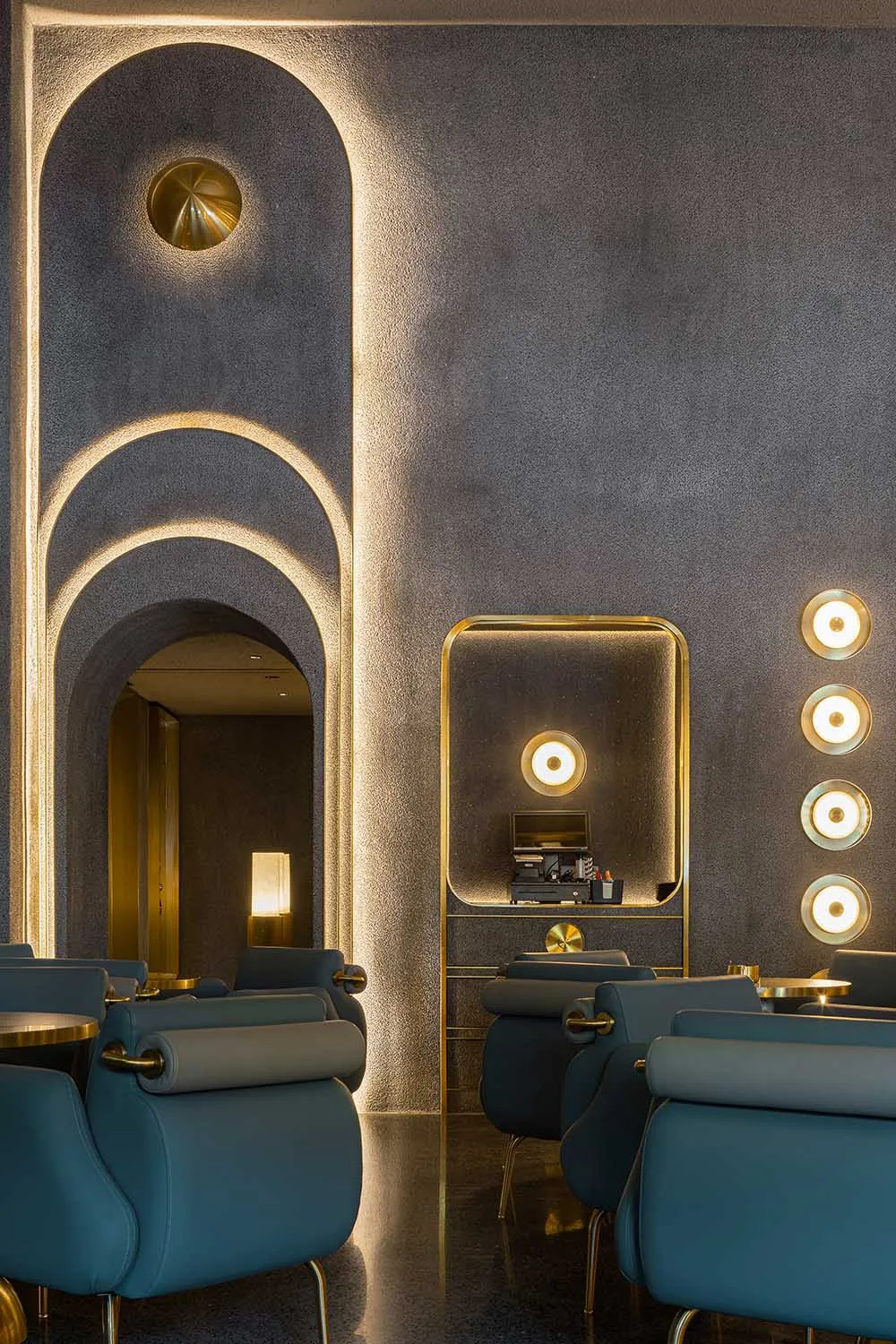 Interior design of a restaurant with industrial-style arches and brass accents.