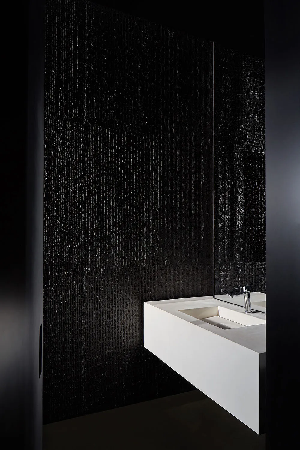 Minimalist bathroom with a concrete wall and white sink.