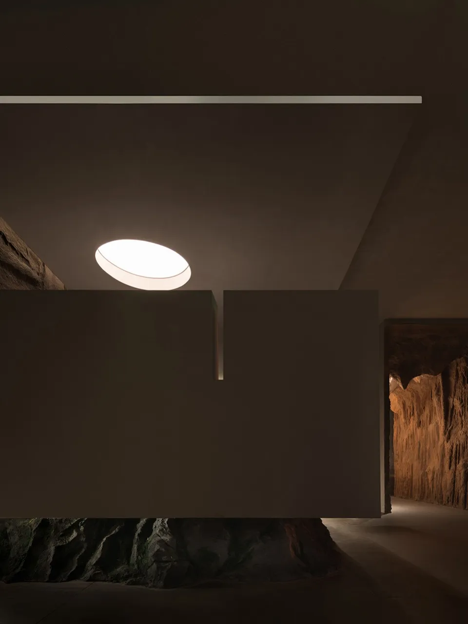 Image of an interior space featuring modern design elements, including concrete walls and a circular light fixture.