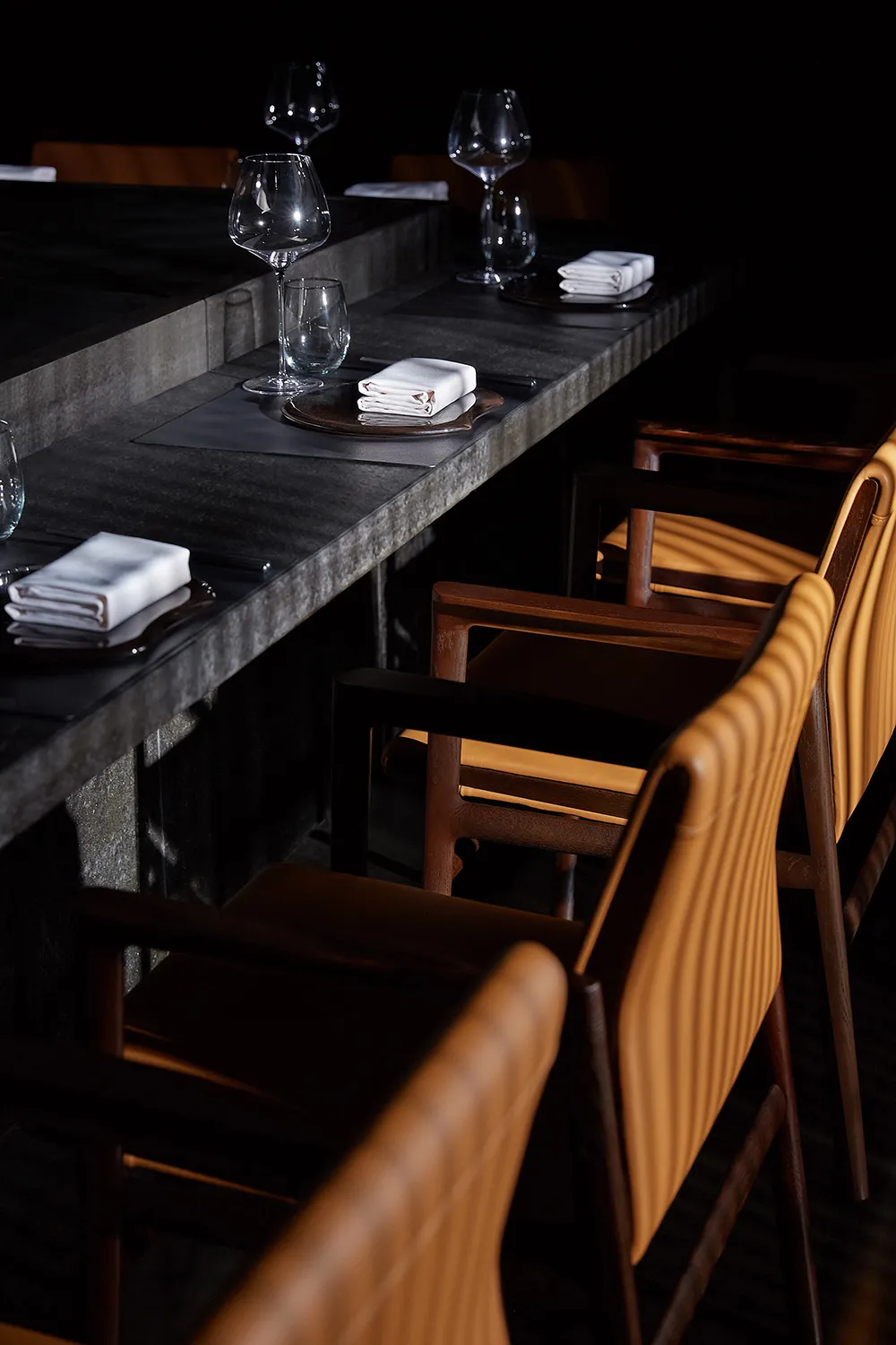 Dining room with concrete and leather elements in a modern restaurant setting.