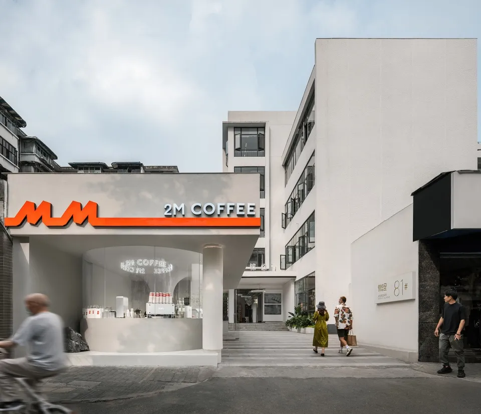 Coffee shop exterior with minimalist design featuring white construction and contemporary aesthetic.