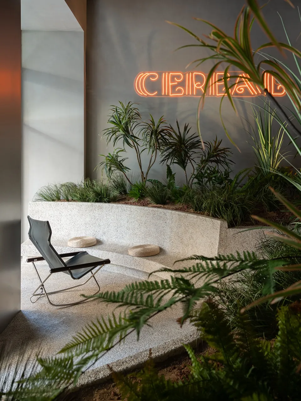 A modern leisure space featuring concrete flooring and seating.