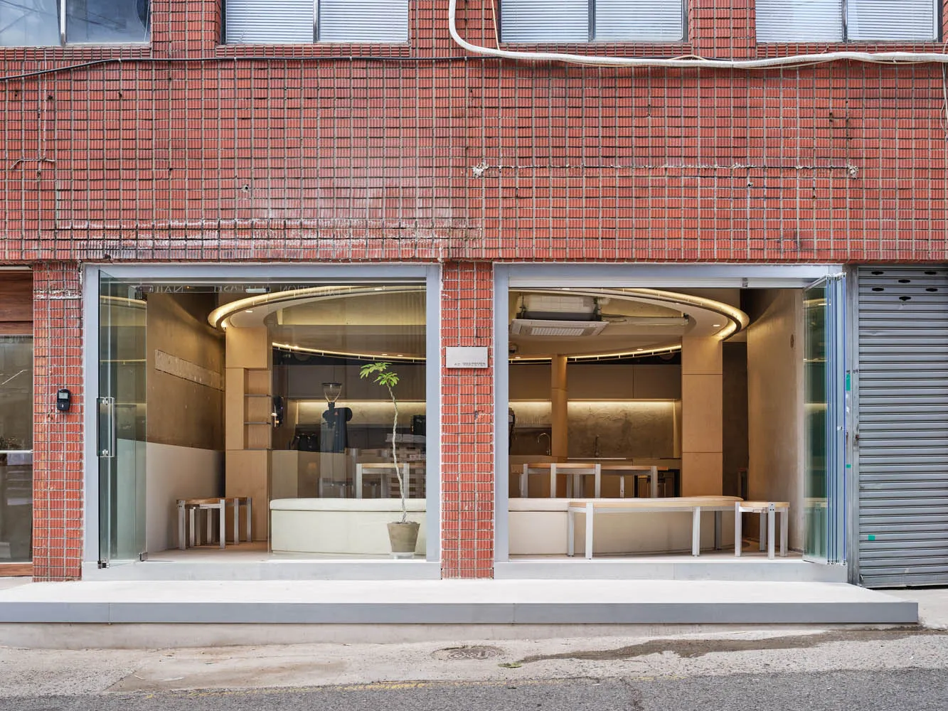 A minimalist storefront with a glass and concrete facade.