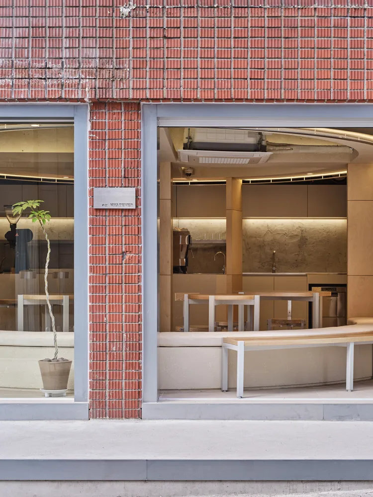 Minimalist storefront with brick facade and glass window.