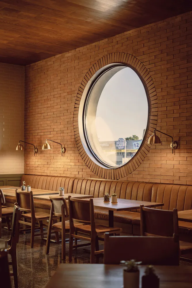 A beautifully designed cafe interior with wooden tables and brick walls.