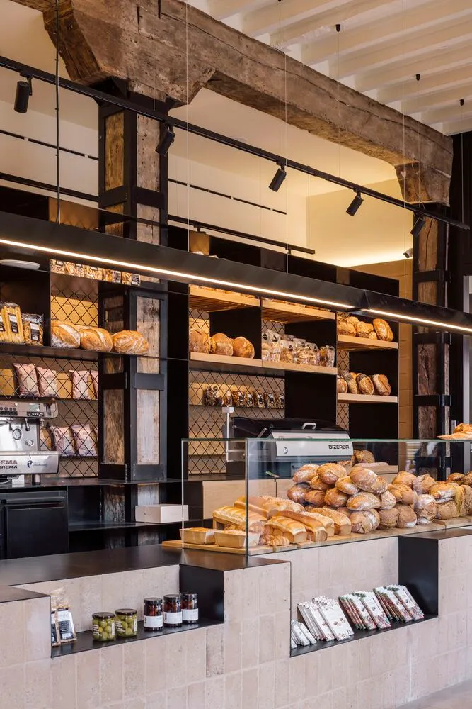 A bakery interior showcasing a mix of wood, metal, and concrete materials.