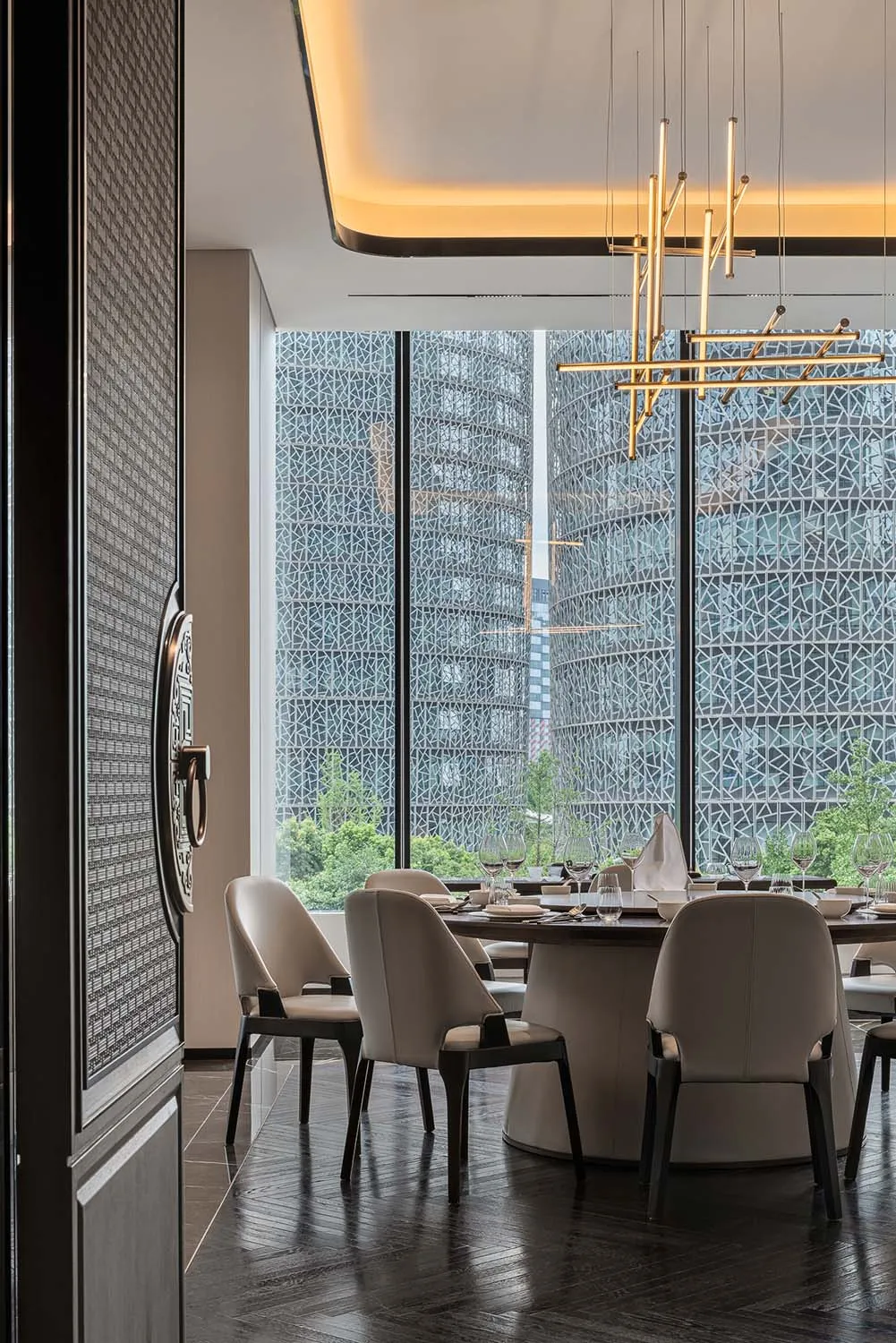 Modern dining room with elegant furniture and large windows.
