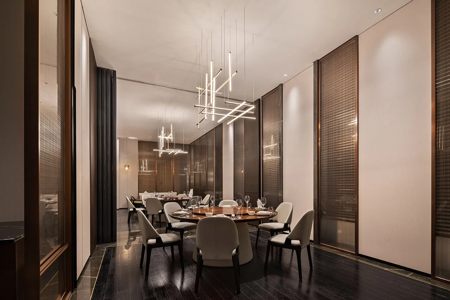 Modern restaurant interior with wooden tables, metal chairs, and glass lighting fixtures.