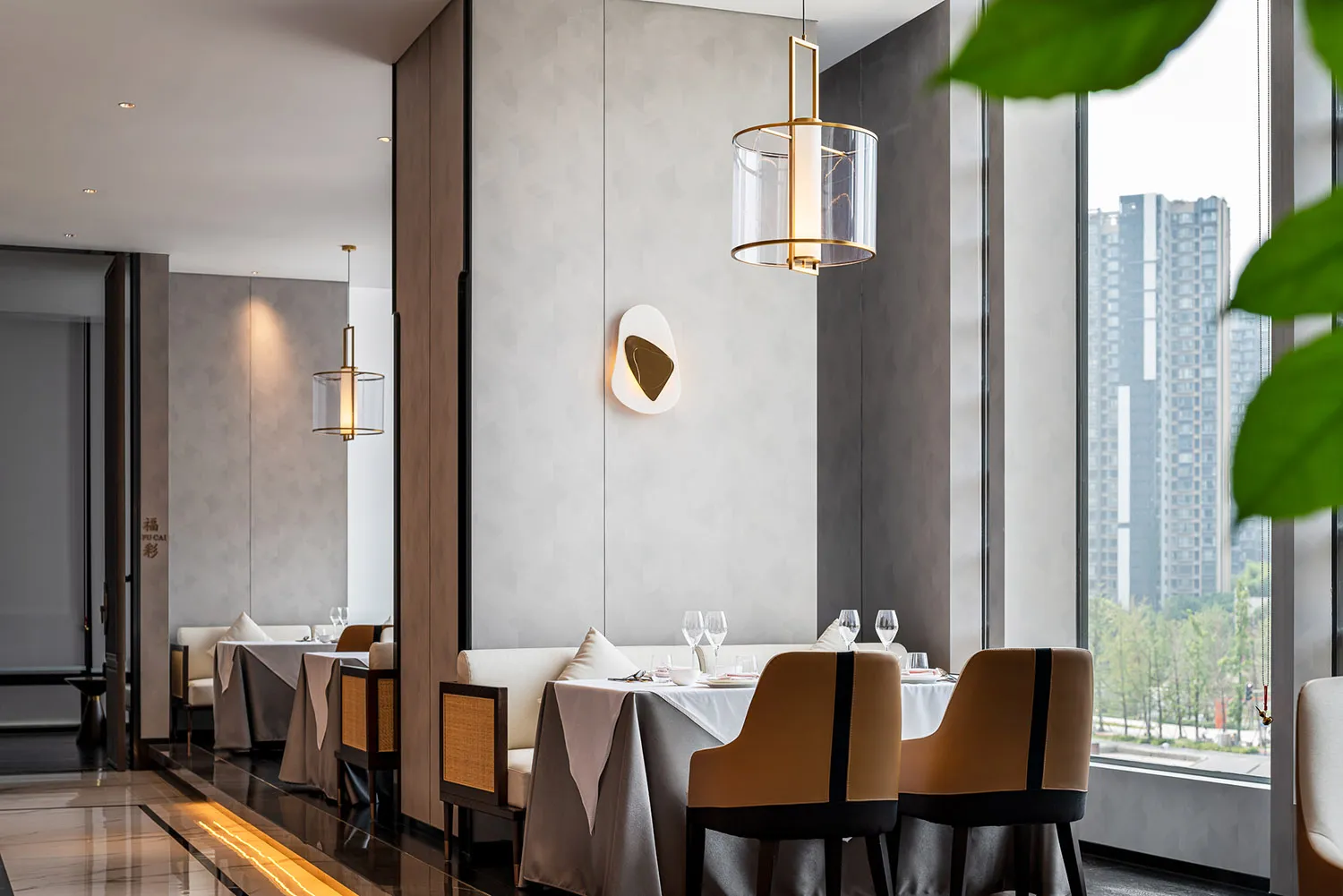 Modern restaurant interior with contemporary design elements and large windows overlooking urban landscape.