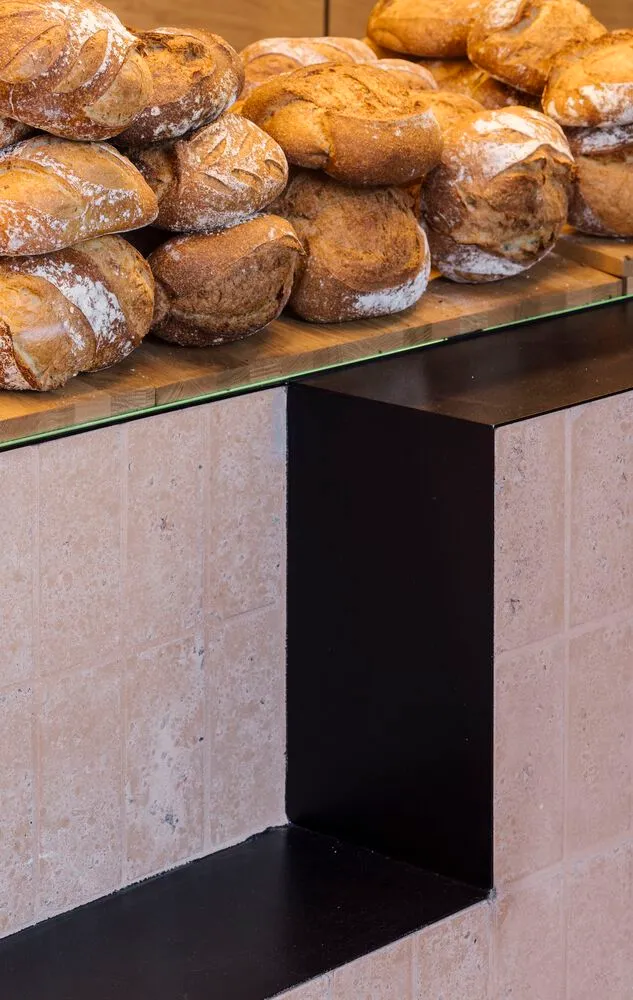 A bakery's bread counter showcasing rustic loaves of bread.