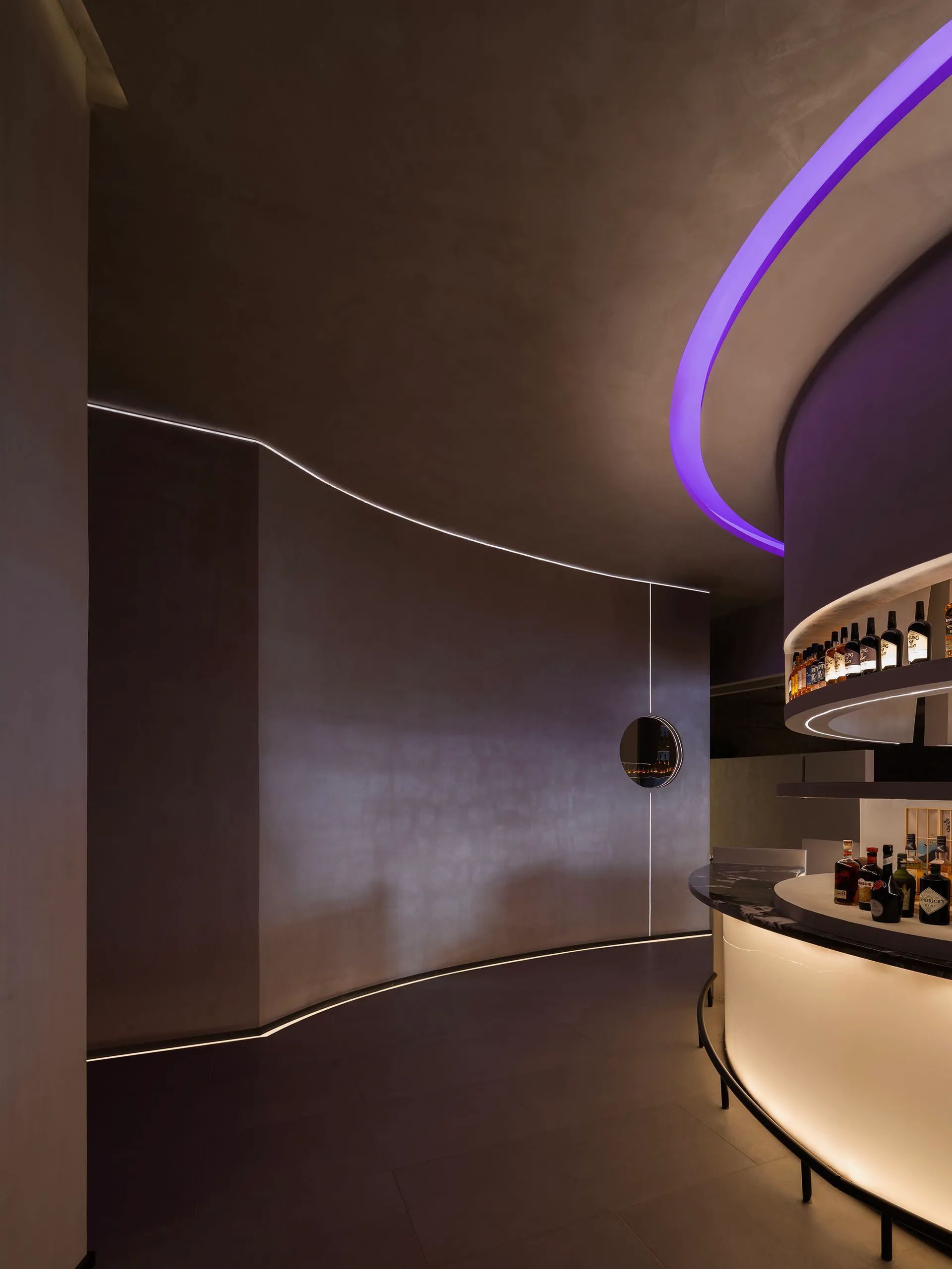 A modern bar with concrete walls illuminated by LED lighting
