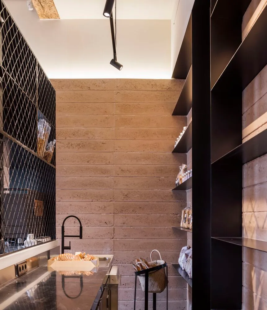 A minimalist pantry with concrete walls and shelves.