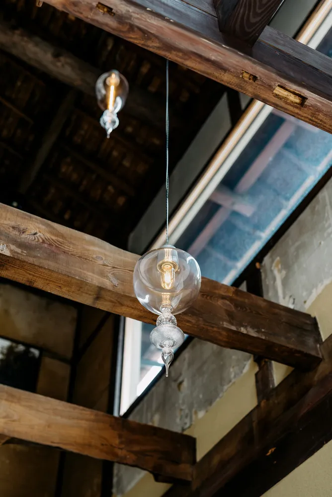 Industrial lighting with glass bulbs and sockets hanging from wooden beams