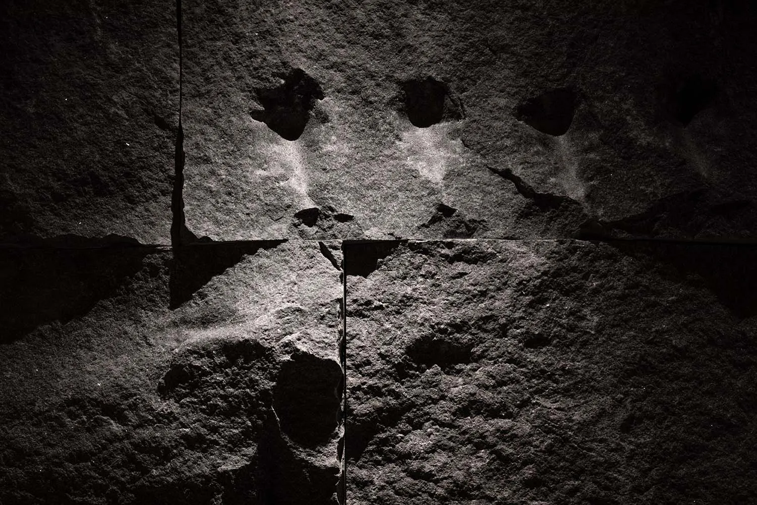 A textured stone wall covered with graffiti