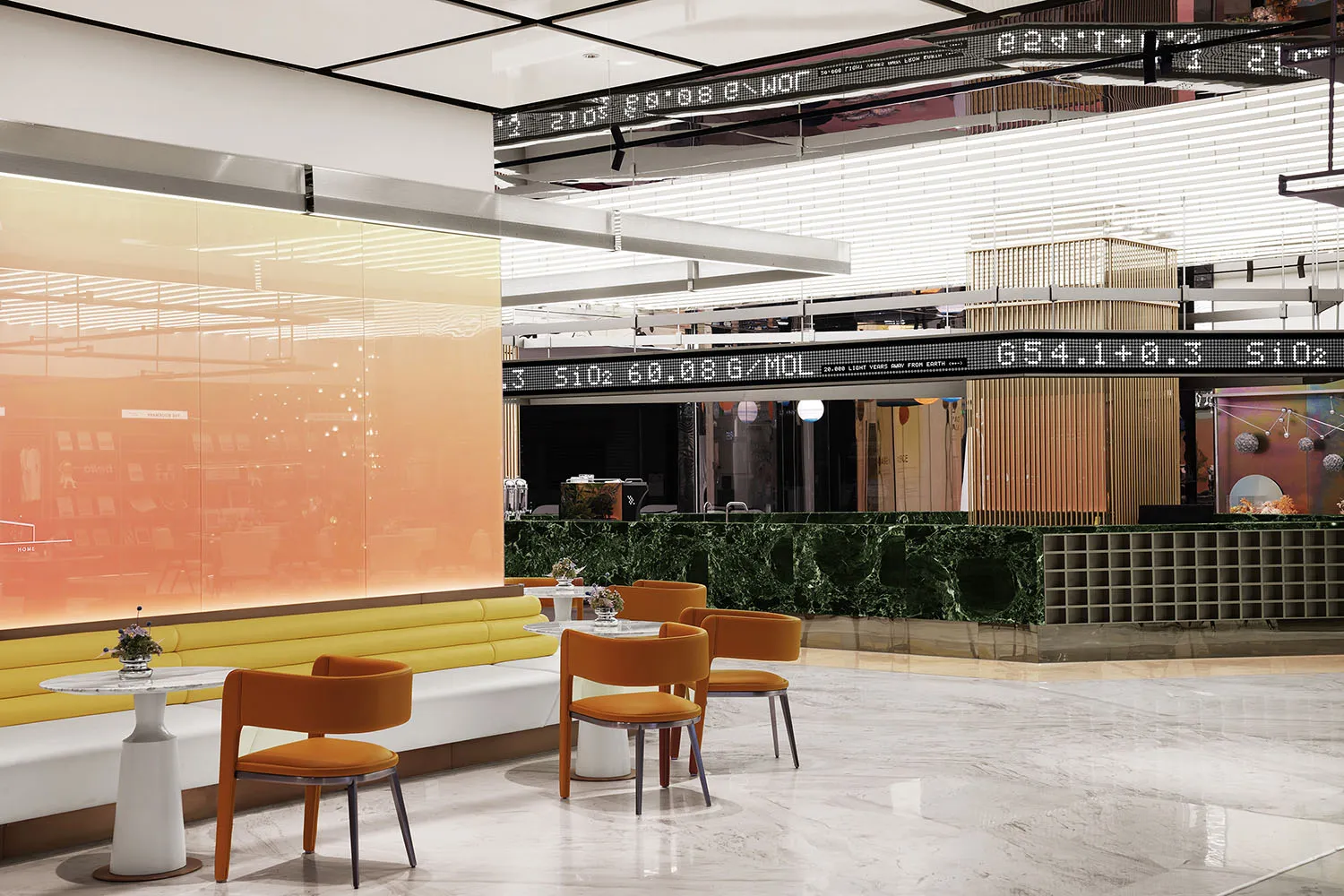 A modern cafe with glass walls, marble floors, and metal seating