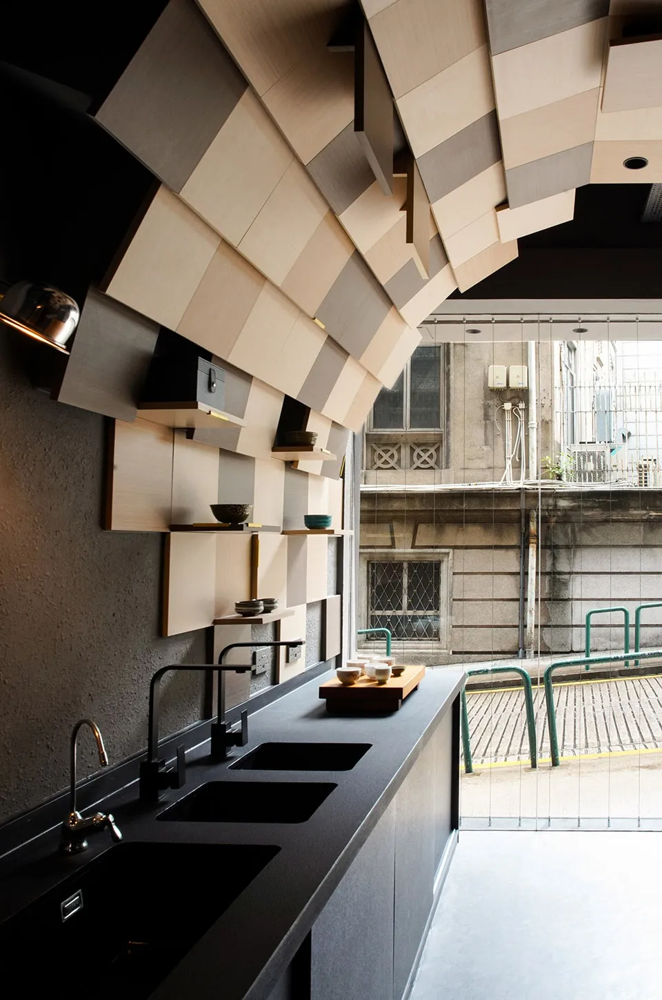 Modern kitchen with a black countertop and wooden shelves