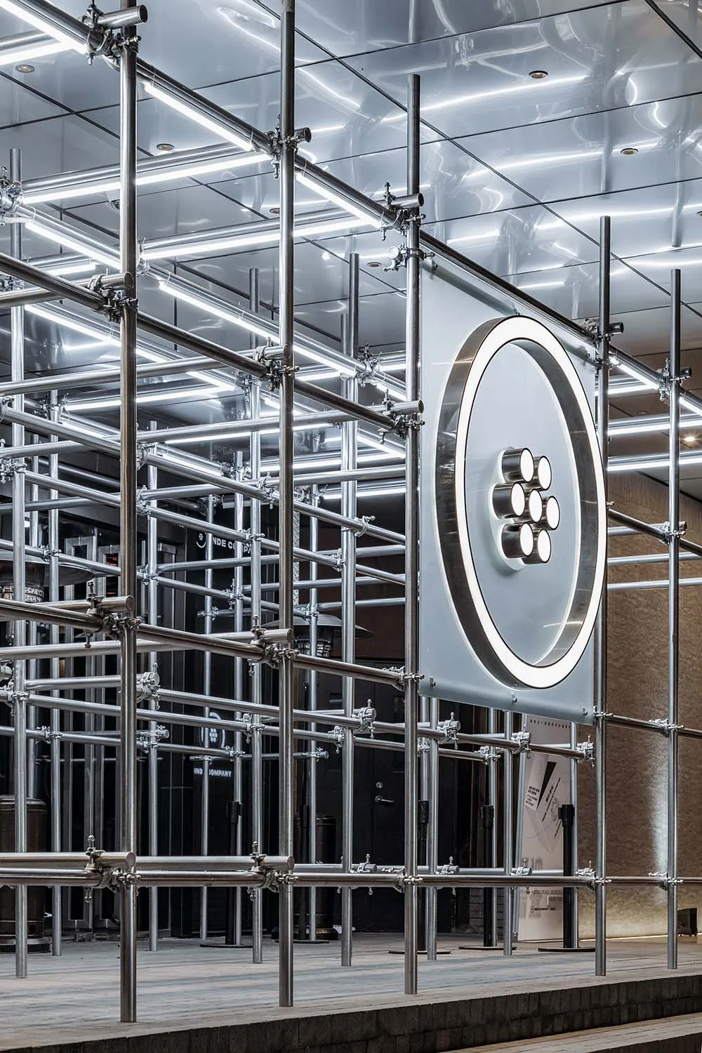 A modern, industrial installation featuring metal scaffolding and lighting elements.