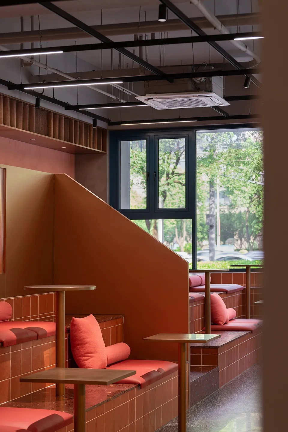 Modern café interior with terrazzo seating and wooden tables.