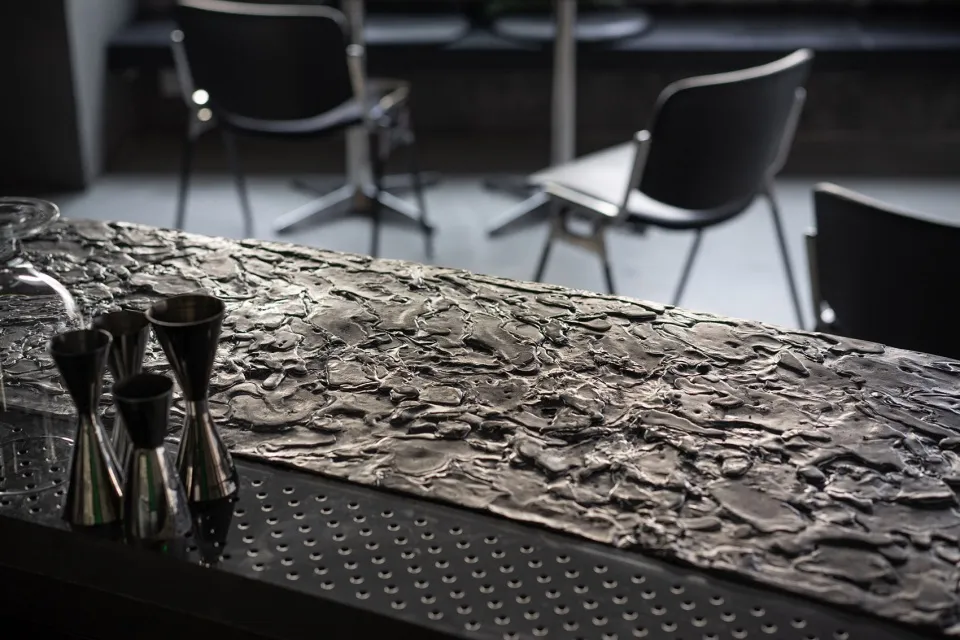 Industrial-style bar counter made of metal with a textured surface.