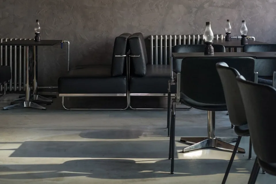 Minimalist interior with black metal furniture and leather seating.