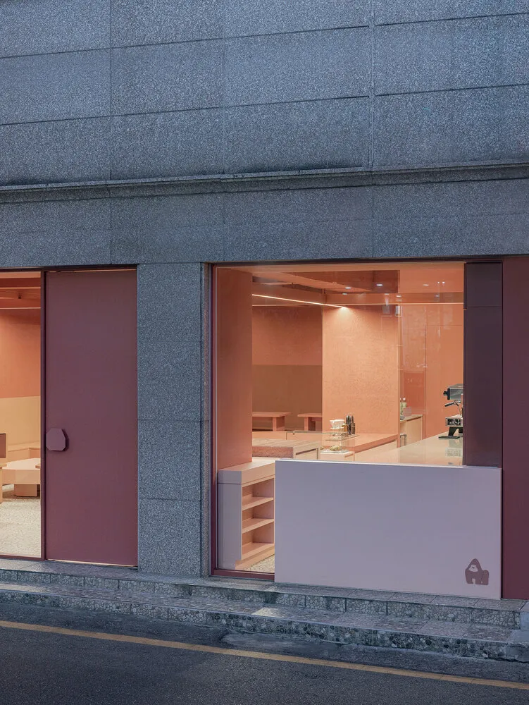 Pink-colored coffee shop interior design with pink painted walls and furniture.