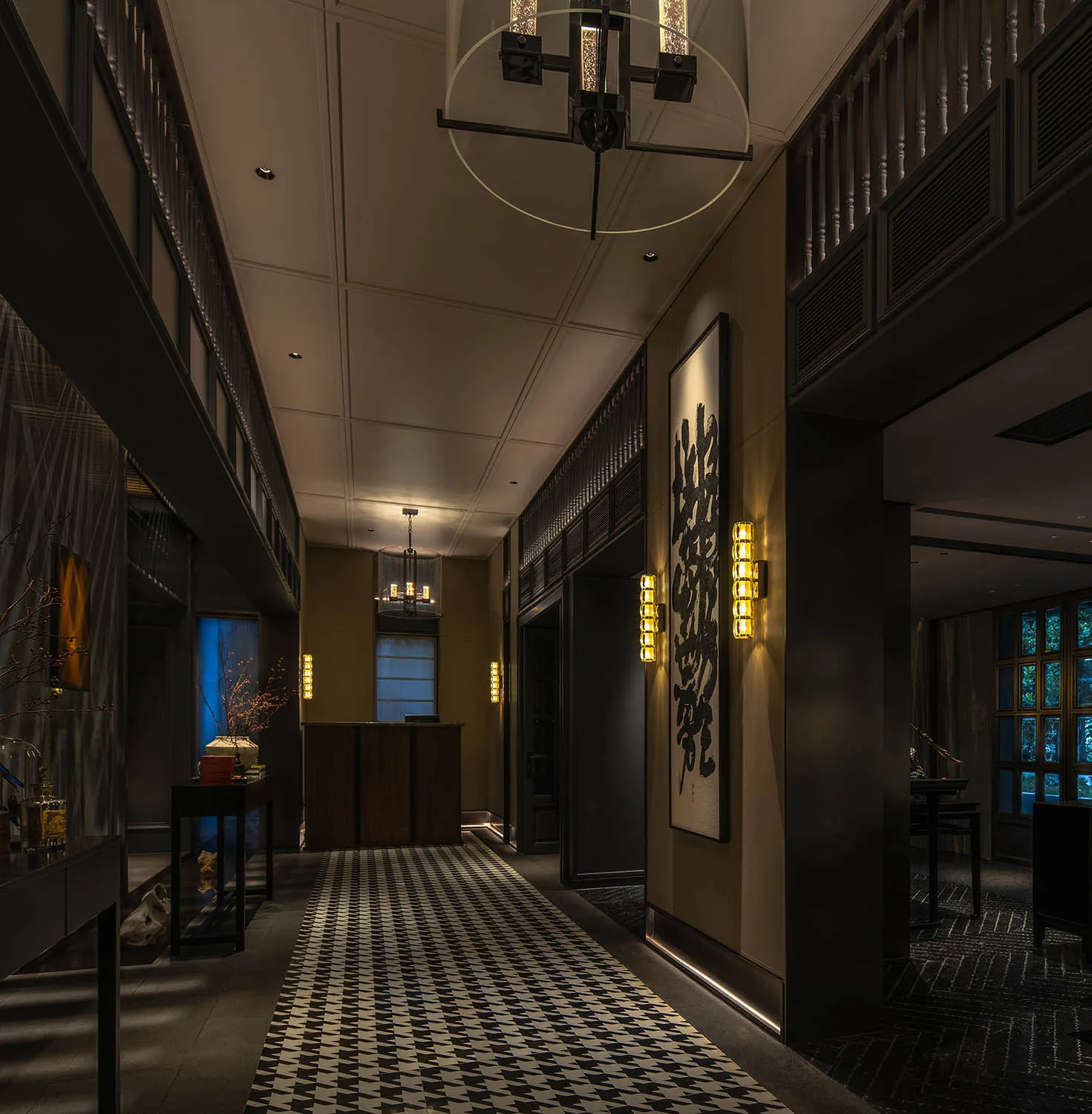 A modern industrial hallway with concrete walls and metal railings, featuring bold patterns on the floor and artistic wall de