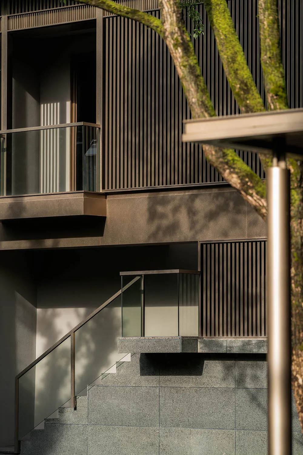 Modern building exterior featuring large glass panels and metal railings.