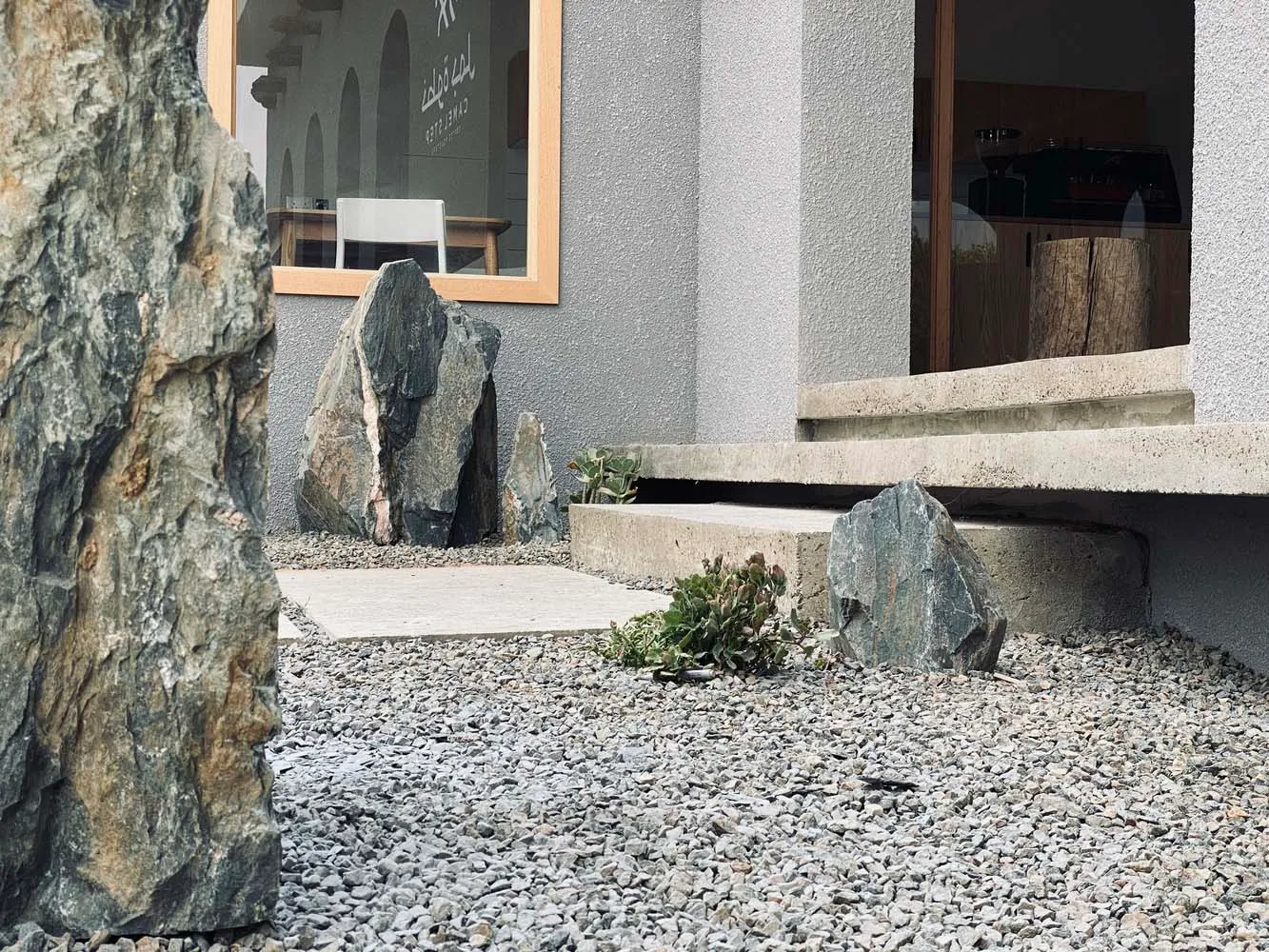 Modern lobby featuring concrete, gravel, and green plants