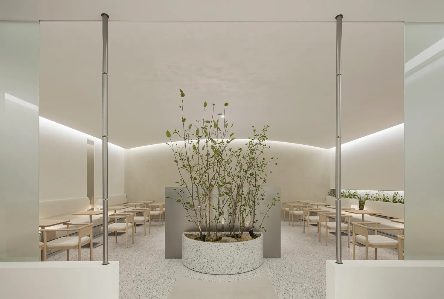 A minimalist modern cafeteria with terrazzo flooring and seating arrangements.