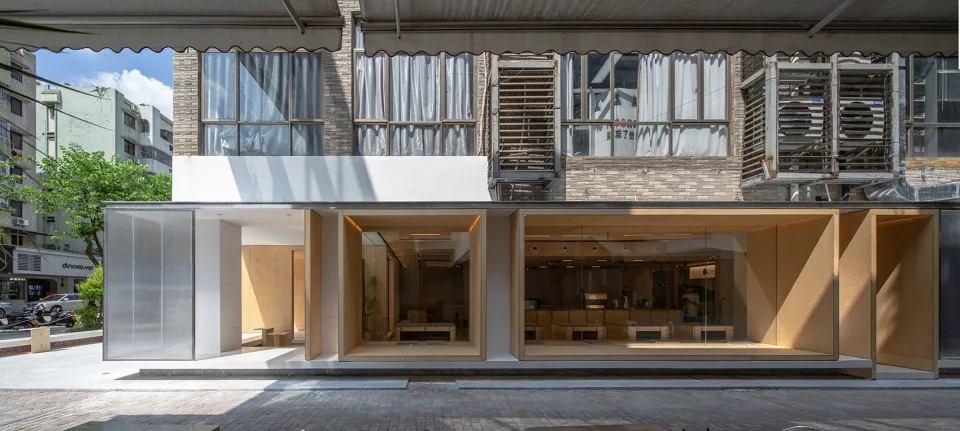 Modern retail storefront with glass windows and brick extension on a city street