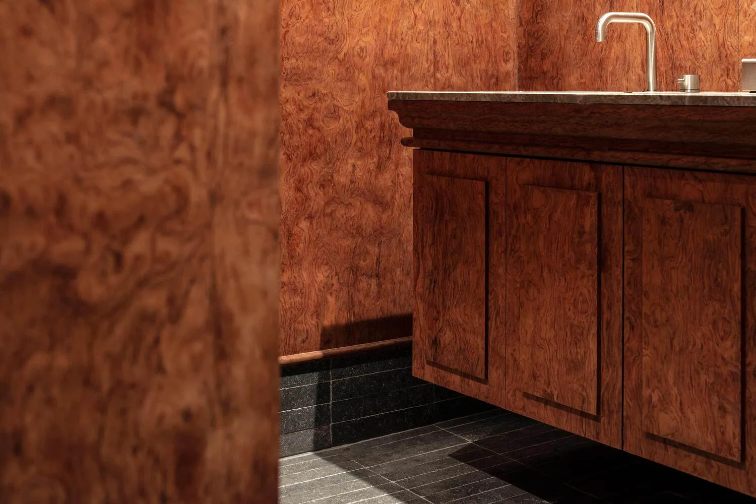 Modern bathroom with wooden paneling and a dark floor.