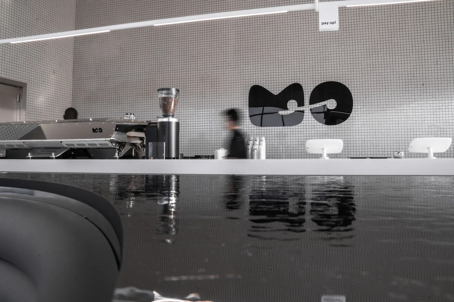 Modern coffee shop interior with a sleek concrete and glass counter.