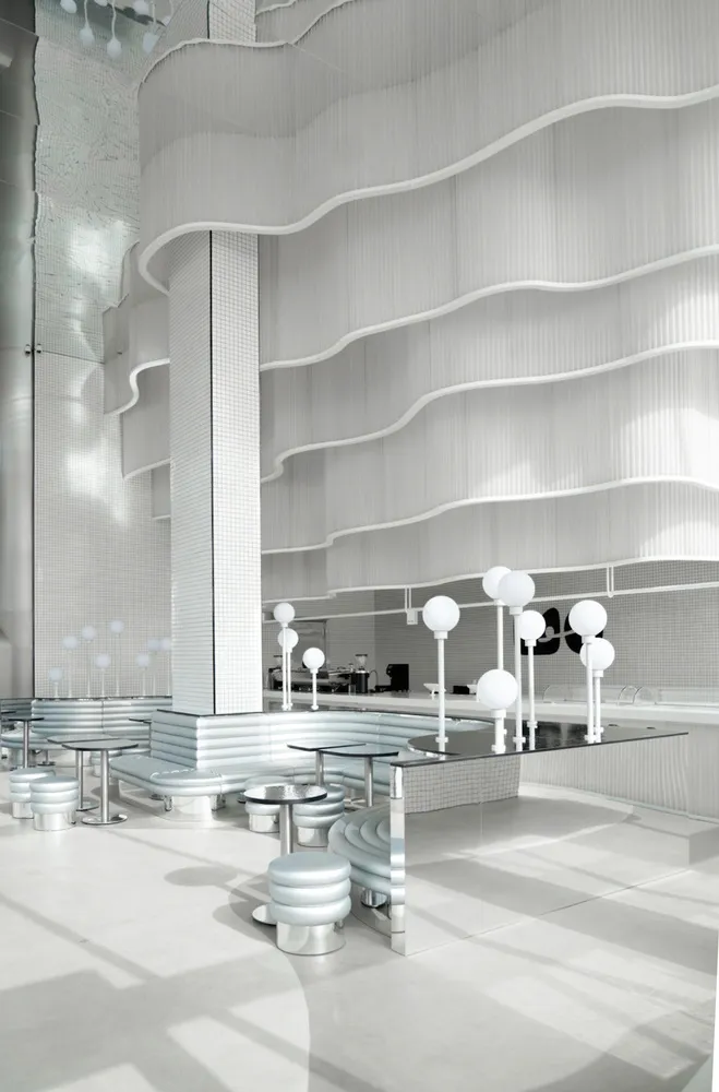 A modern coffee shop featuring a metallic counter with a sleek, minimalist design.