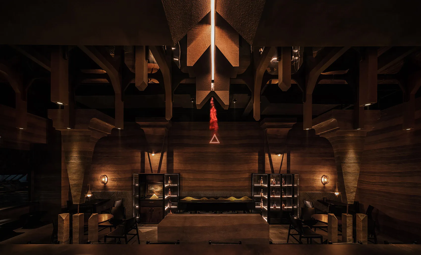A modern industrial restaurant interior with concrete walls, high ceilings, and warm lighting.