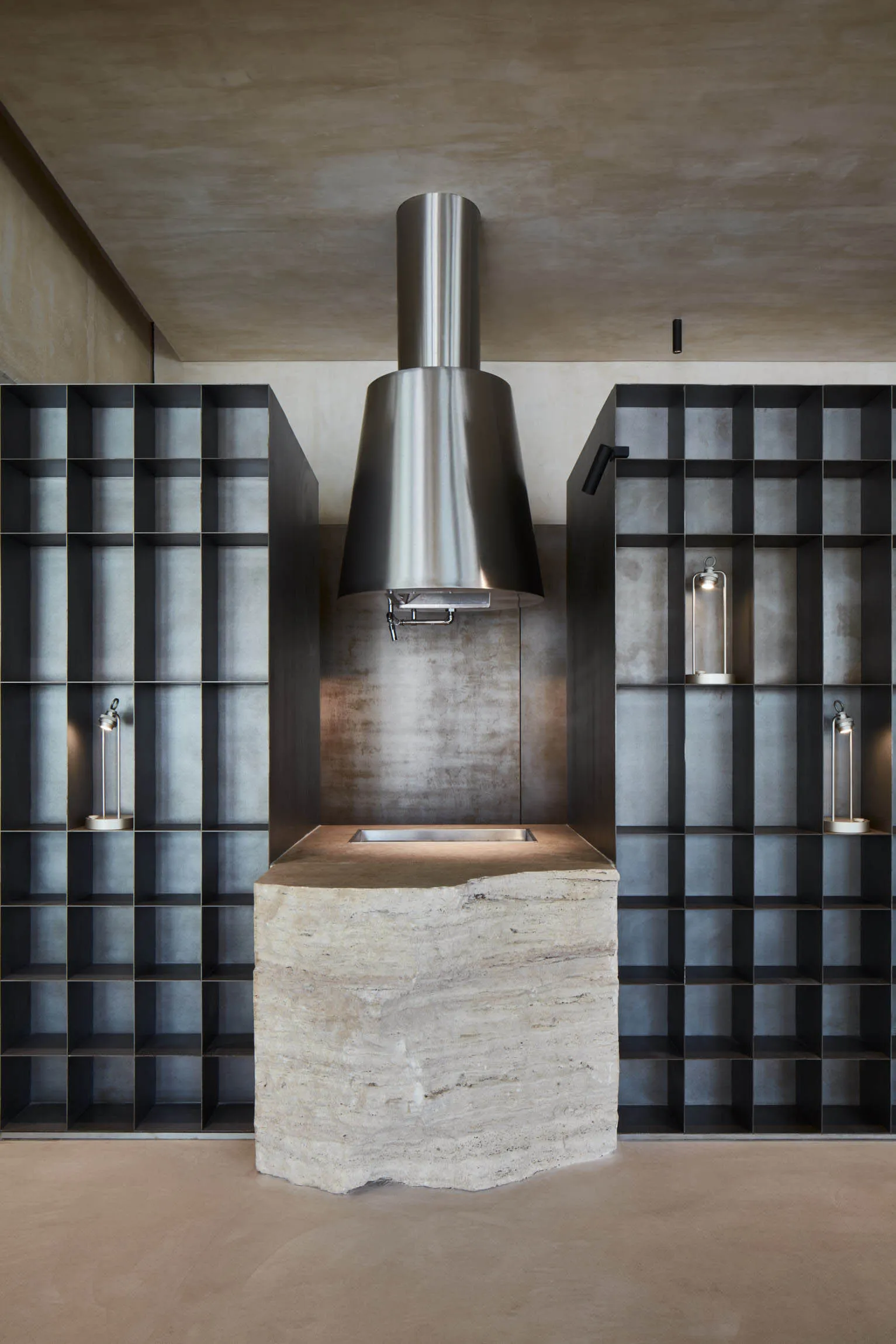Modern kitchen with metal and stone elements, featuring a sleek countertop and minimalist design.