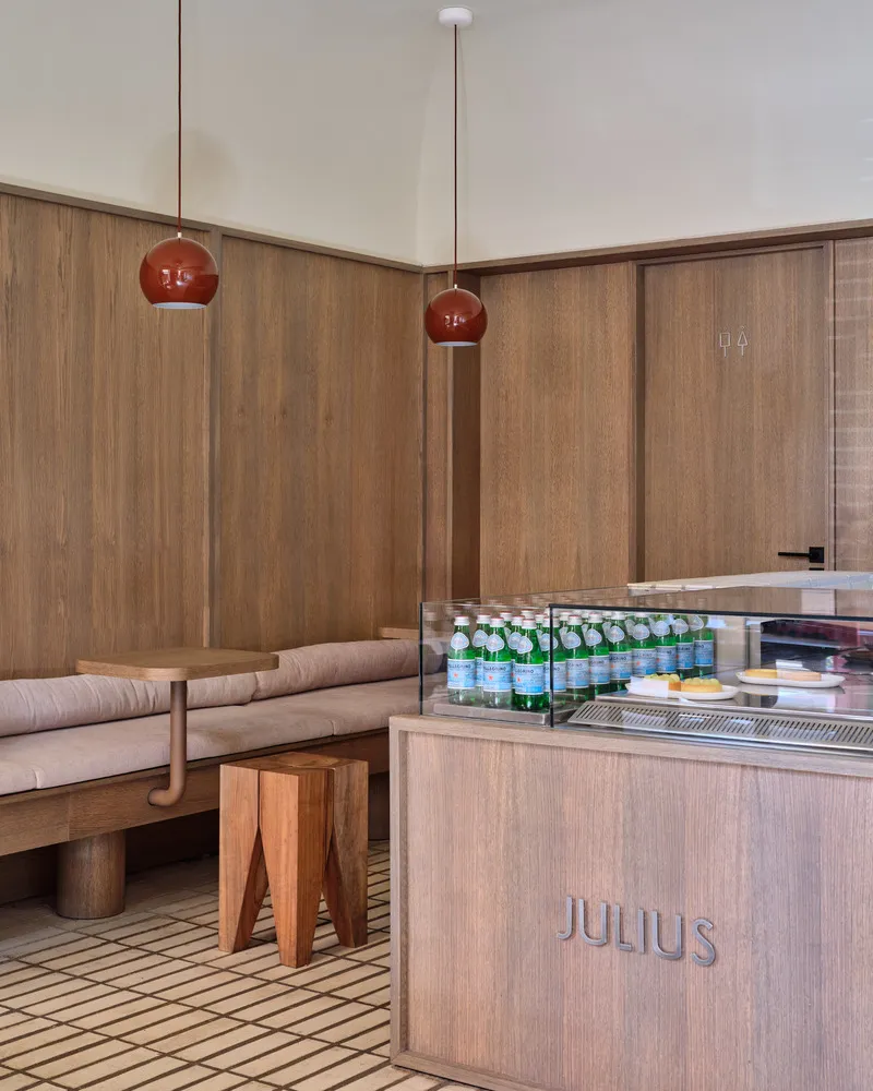 Interior design of a modern restaurant featuring wooden seating and glass elements.