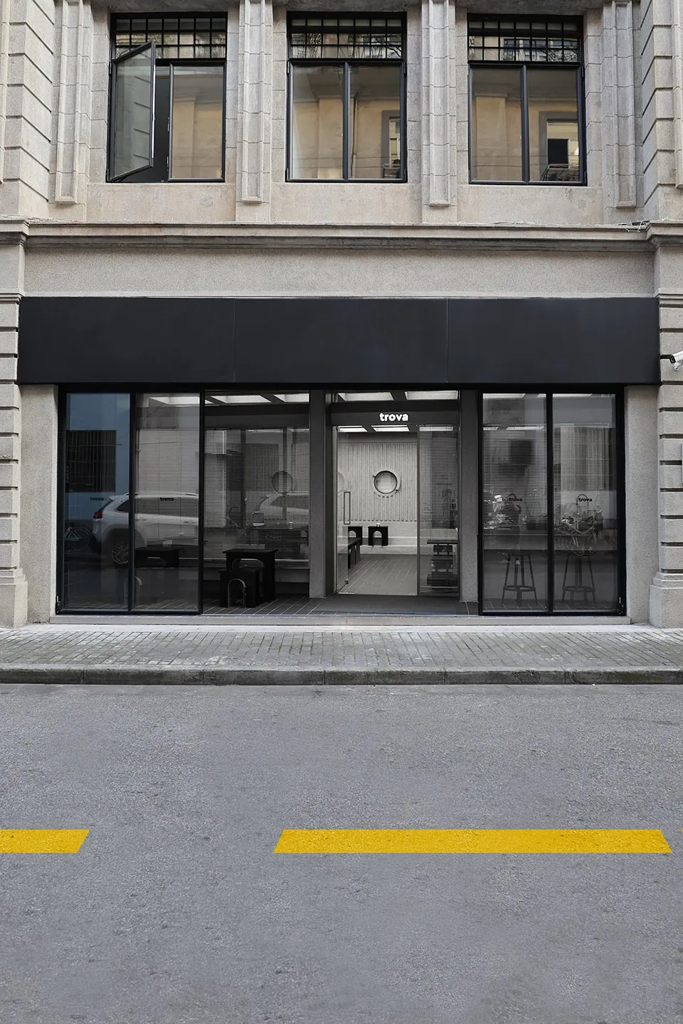 A modern retail storefront with large glass windows, concrete accents, and minimalist design.