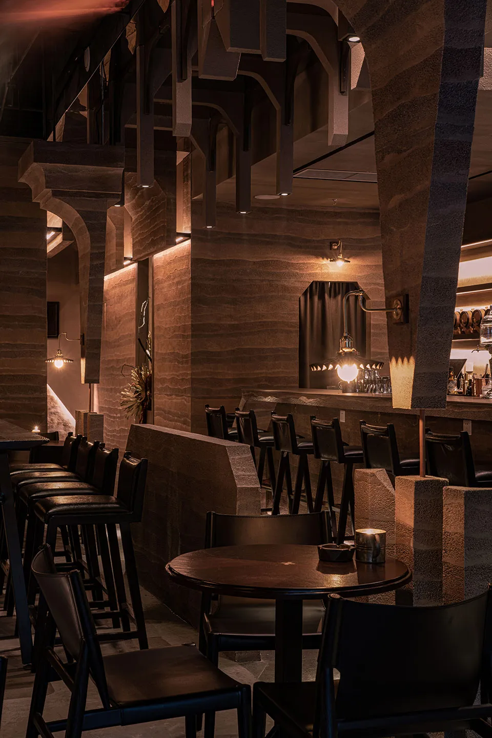 Industrial design cafe bar with stone walls, leather seating, and metal accents