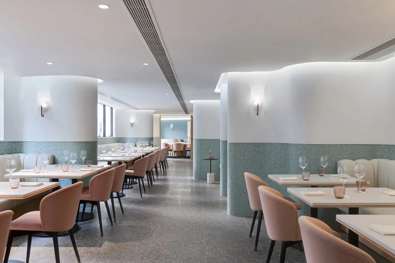 A minimalist restaurant interior featuring terrazzo accents and modern design elements.