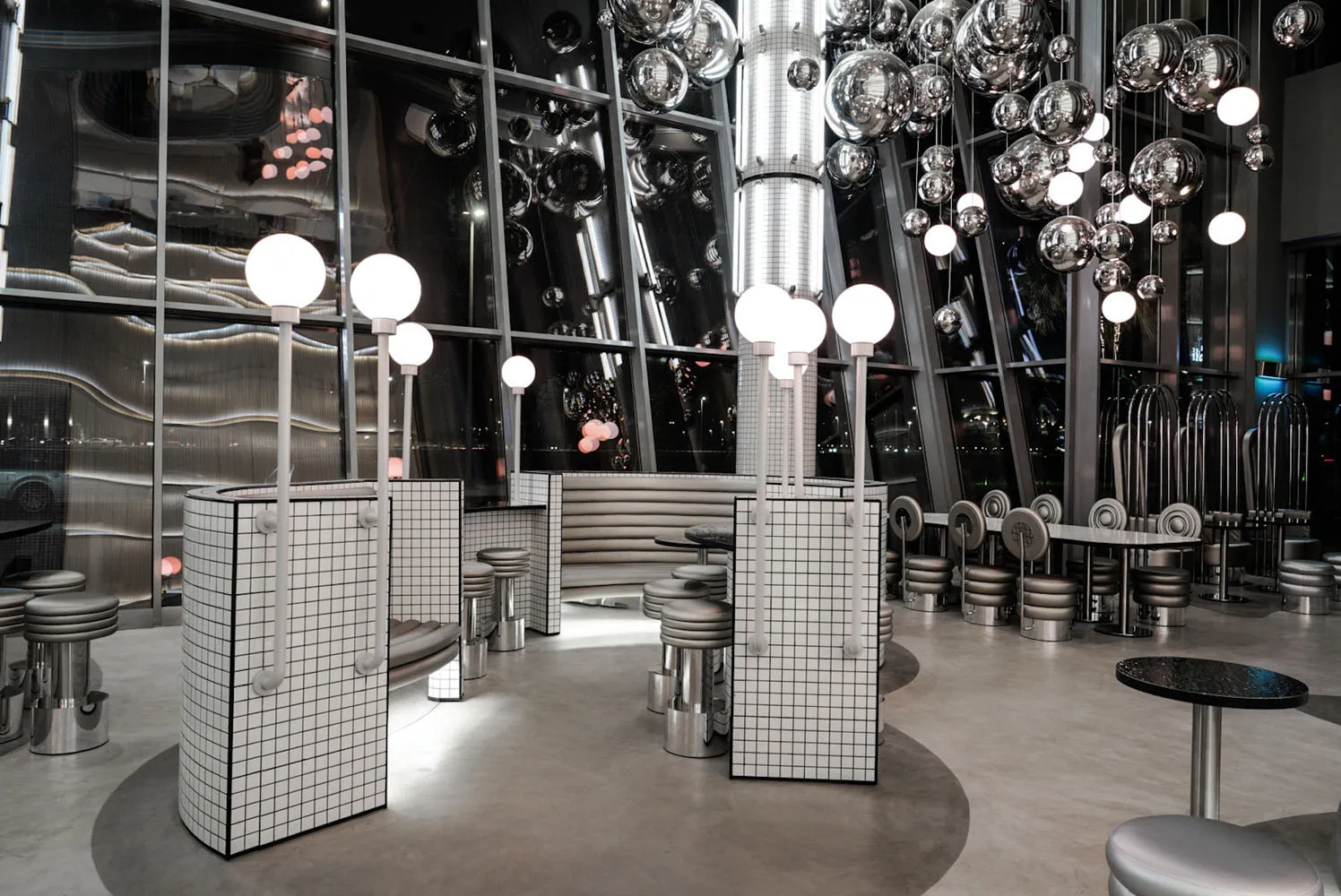 A modern restaurant interior with metallic elements and reflective surfaces.