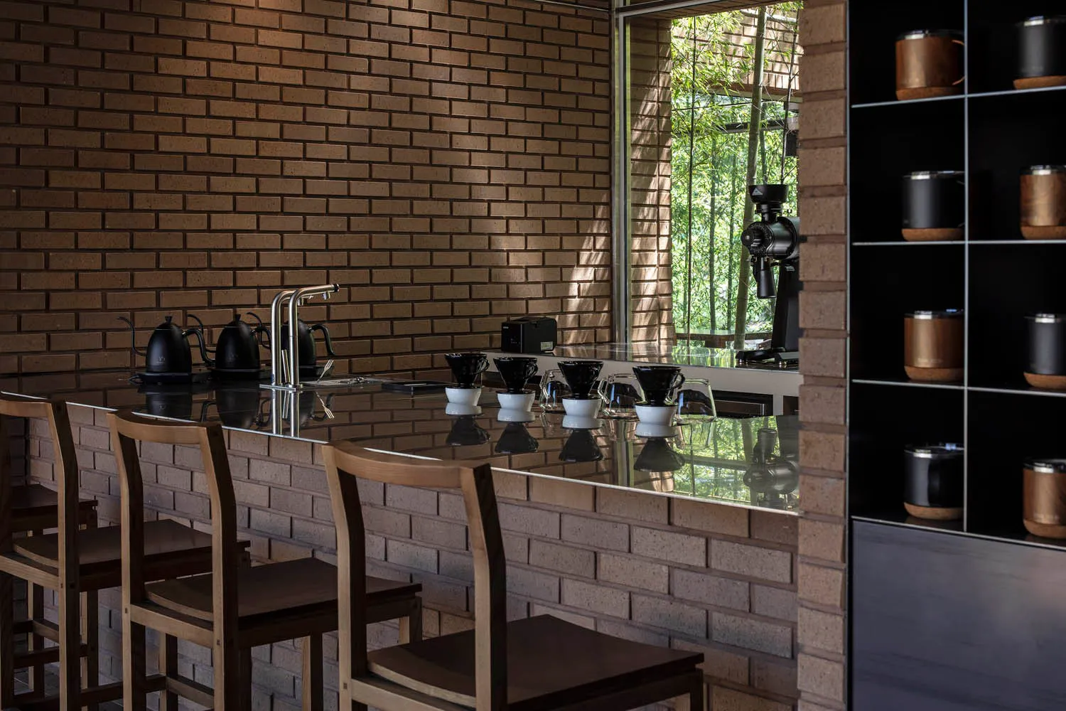 Modern coffee shop interior with brick walls and concrete countertops.