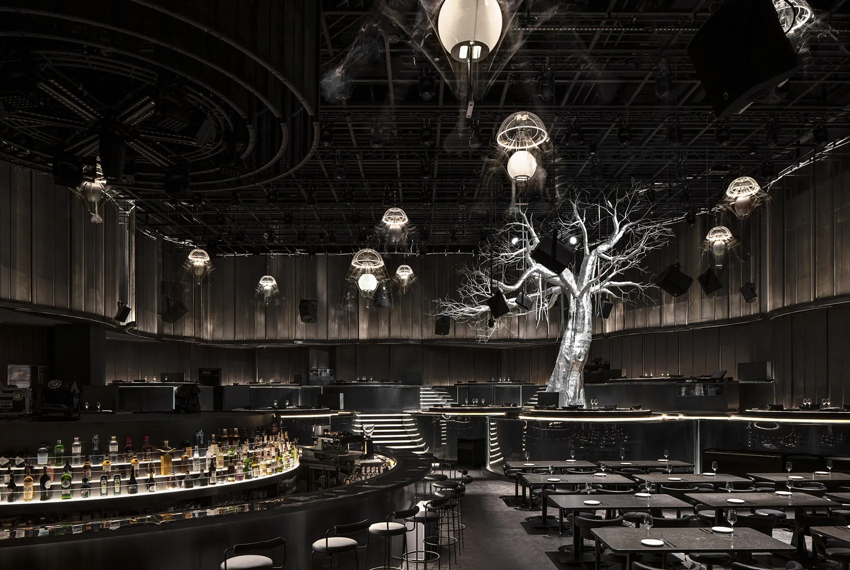 An interior design of a modern restaurant bar with metallic textures and industrial lighting fixtures.