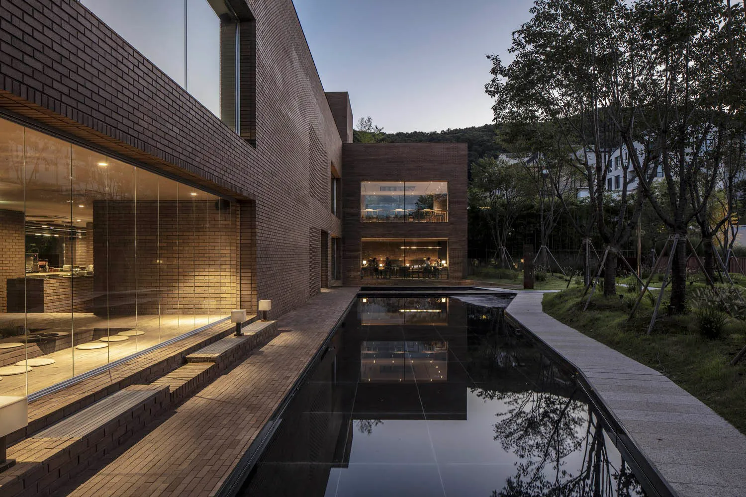 A modern residential exterior featuring brick and glass materials.