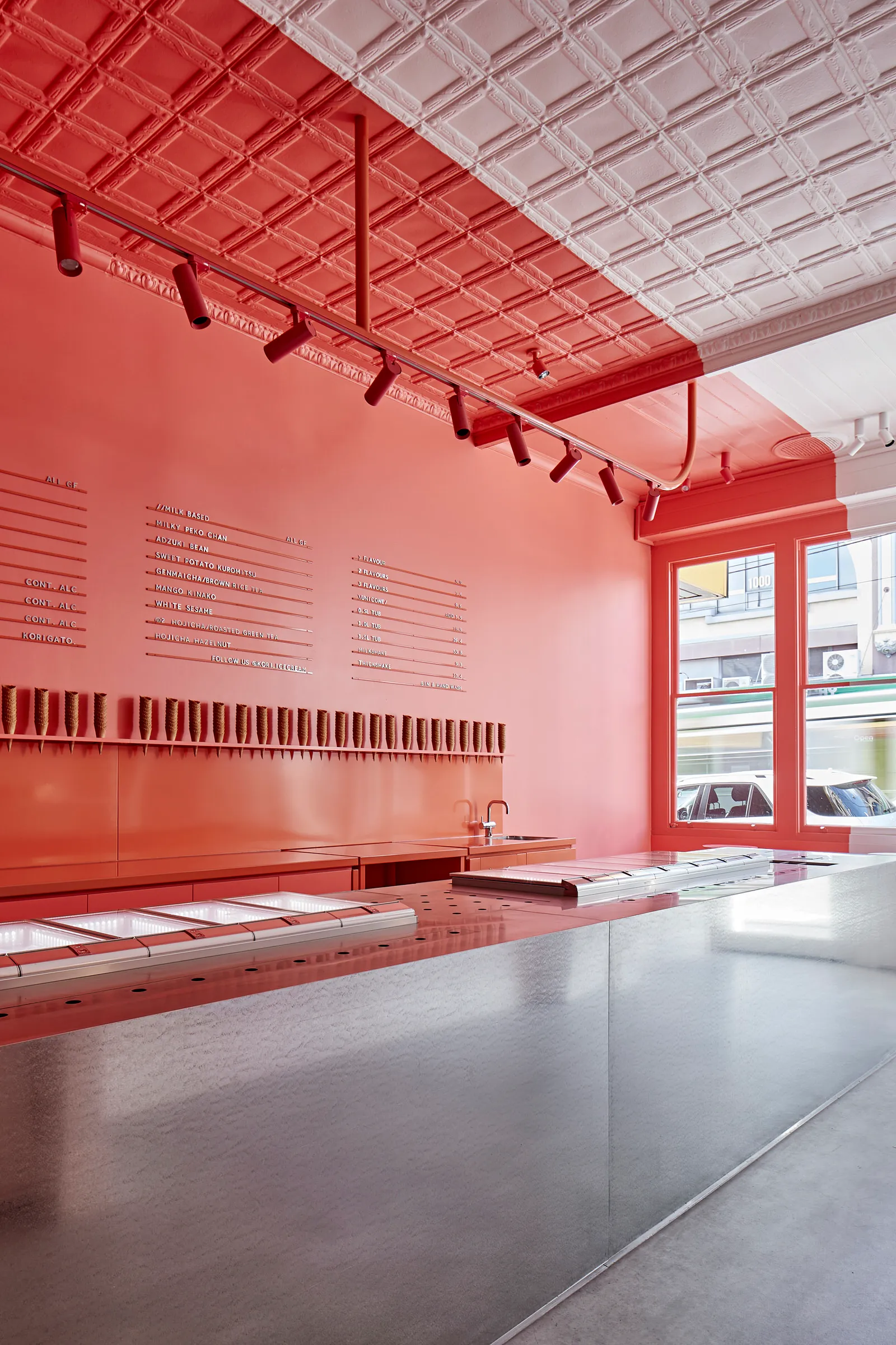 現代極簡餐廳內部，擁有金屬表面、粉彩牆面，以及俐落吧台。