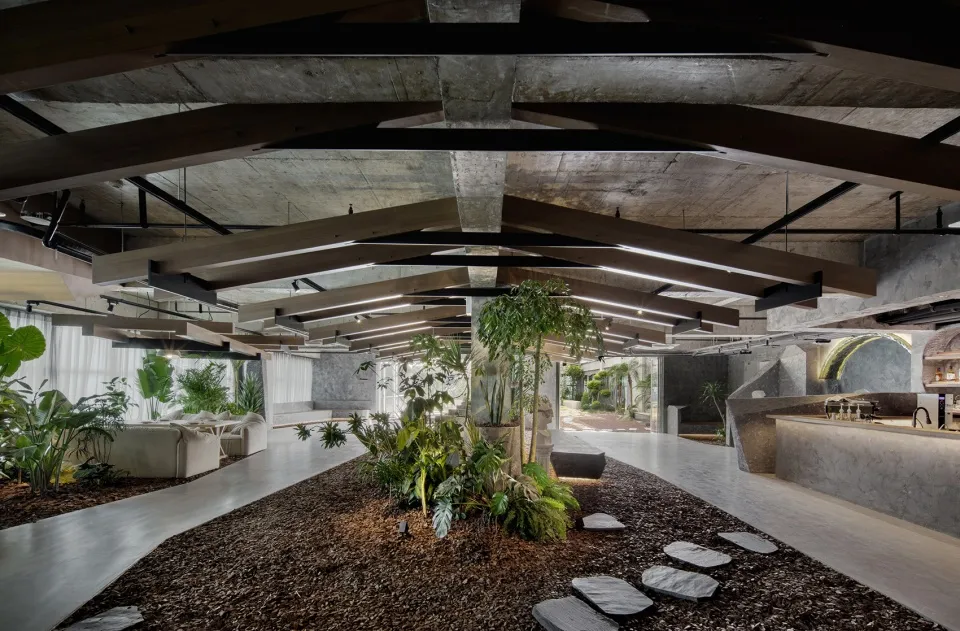 現代工業風餐廳室內,混凝土地板、裸露木樑與盆栽植物。